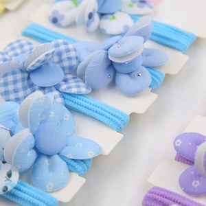 Gros plan de bandeaux bébé en tissu avec motifs à carreaux bleus et fleurs mauves