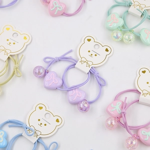 Detail of macaron color elastic hair ties set with heart charms on bear display cards