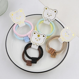 Detail of high-elastic braided hair ties with bear packaging and handmade labels