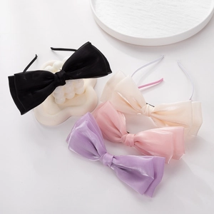 Détail de quatre serre-têtes à nœuds en tulle en noir, crème, rose et tons violets