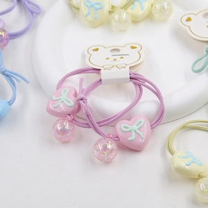 Close-up of pink heart-shaped charms and bow detail on high elastic hair bands set