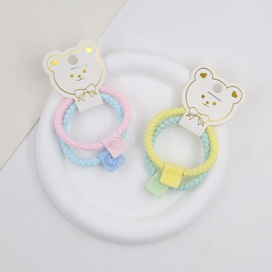 Close-up of woven high-elastic hair ties with smiley face charms on bear-shaped card