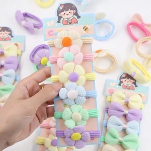 Gros plan d'élastiques à cheveux fleurs pour filles en tissu aux tons macarons