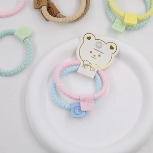 Detailed close-up of woven high-elastic hair ties with cute smiley face charms and card