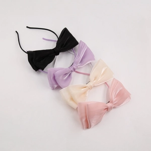 Détail de quatre serre-têtes en organza avec nœuds en noir violet beige et rose poudré