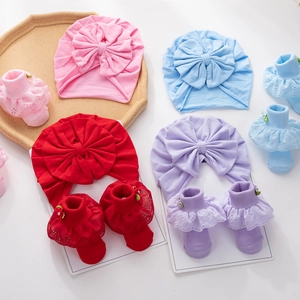 Detailed set of newborn cotton hats with large bows and matching lace trim flower socks
