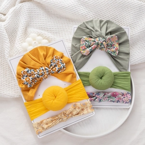 Detalle del conjunto de gorro donut y diadema floral para bebé en tarjeta de muestra