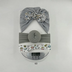 Detalle del set de diademas para bebé con estampados de arcoíris y nudos de punto gris