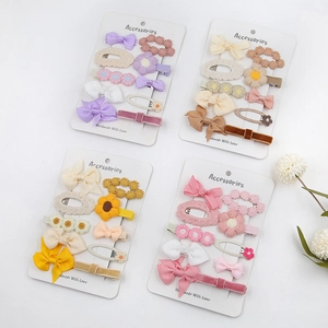 Détail de dix barrettes à cheveux faites à la main avec nœuds et fleurs pour petites filles
