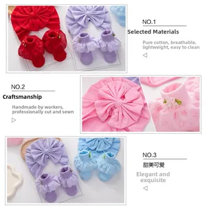Close-up of cotton baby turban hat and lace socks set with bows and embroidery