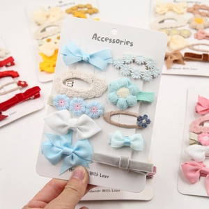 Détail d'un lot de 10 barrettes artisanales en tissu avec fleurs et nœuds pour fillettes