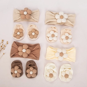 Detailweergave van gebreide babyhoofdbanden en sokken met 3D-katoenen bloemen