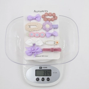 Détail de l'ensemble de 10 barrettes pour bébé pesées sur une balance pour le poids précis