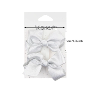 Set of two silver satin bow hair clips for girls on a white retail display card