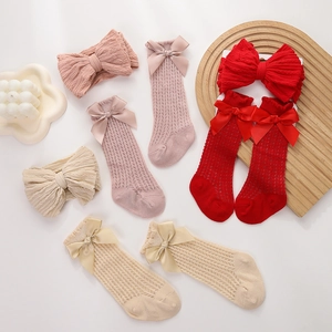 Detail of baby headband and breathable mesh socks set with large satin bows in three colors