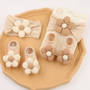 Detail van de neutrale baby-hoofdband en sokkenset met bloemen voor baby's van 0-2 jaar