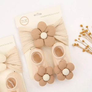 Detail van de baby hoofdband en sokken set met 3D bloemen in zachte crème en bruintinten