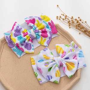 Detail von zwei Oster-Baby-Stirnbändern mit bunten Hasen- und Ei-Prints auf Waffelstoff