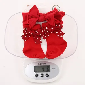 Close-up of lightweight 41.6g red baby headband and heart pattern bow socks gift set