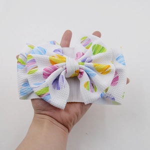 Detailaufnahme Baby-Waffelstirnband mit großer Schleife und bunten Ostereier-Drucken