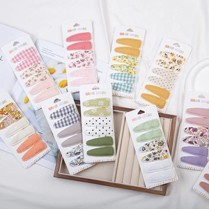 Détail de barrettes en tissu fleuri en forme de goutte sur cartes fait main