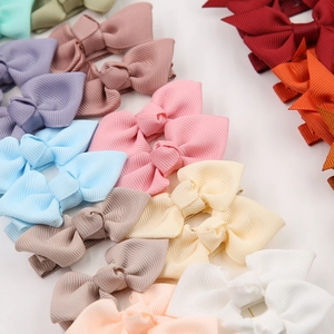 Detailed close-up of colorful ribbed grosgrain ribbon bow hair clips for baby girls