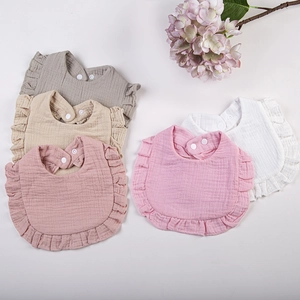 Soft ruffled cotton gauze baby bibs in five assorted neutral colors for infants