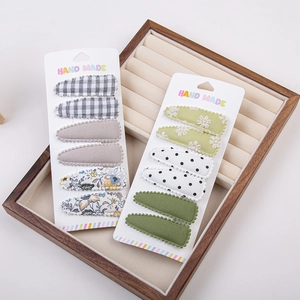 Détail de l'ensemble de barrettes à cheveux en tissu fait main pour filles sur plateau