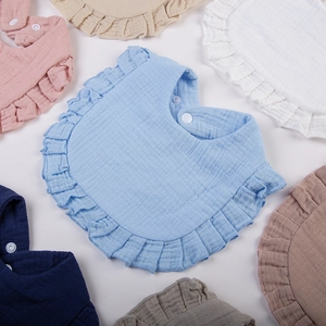 Detail of ruffled edges on multi-layered cotton gauze baby bibs in Morandi colors