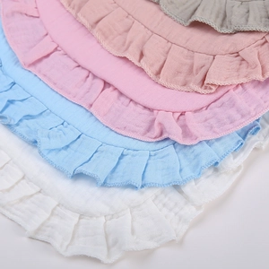 Close-up of soft muslin cotton baby bibs with ruffle edges in multiple Morandi colors