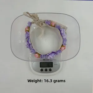 Detailaufnahme des leichten 16,3g Blumenstirnbands mit Spitzenbändern auf einer Waage