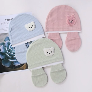 Detail view of organic cotton baby hat and mittens set with cute animal patches