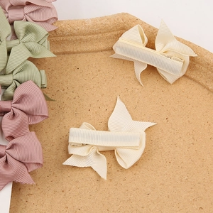 Three-piece baby bow hair clip set in sage green and cream ribbed grosgrain ribbon