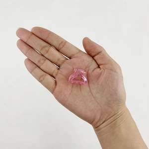 Mini pink glitter resin hair claw clip held in hand to show the small size and texture