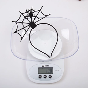 Dettaglio del cerchietto di Halloween leggero 12g con ragnatela nera su una bilancia