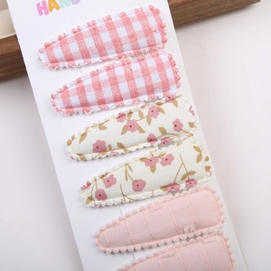 Détails de 6 barrettes en tissu rose à fleurs et carreaux sur carte de présentation