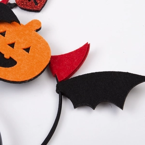 Dettaglio del cerchietto di Halloween con zucca in feltro e ali di pipistrello nere