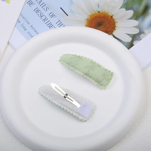 Barrettes à cheveux en tissu vert clair brodé avec motif palmier sur plateau