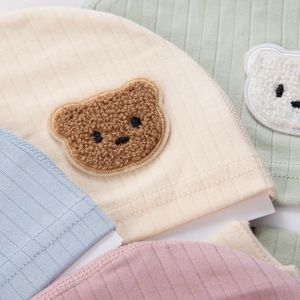 Detailed view of soft ribbed organic cotton newborn beanies with cute plush bear embroidery