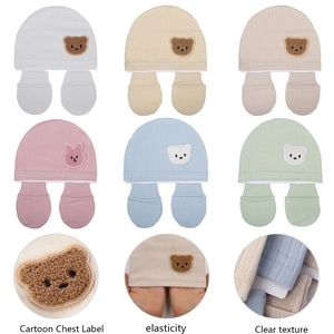 Detail view of organic cotton baby beanie and gloves set in six pastel colors