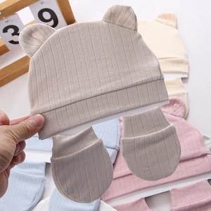 Detalle de gorro para recién nacido con orejas de oso y manoplas de punto acanalado
