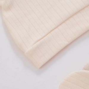 Primer plano del gorro para recién nacido de algodón acanalado crema y sus costuras