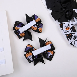 Dettaglio dei fiocchi per capelli di Halloween con stampe di zucca e clip in nastro