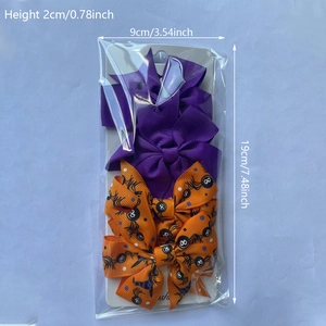 Dettaglio di fermagli per capelli a fiocco viola e arancioni con ragni per Halloween