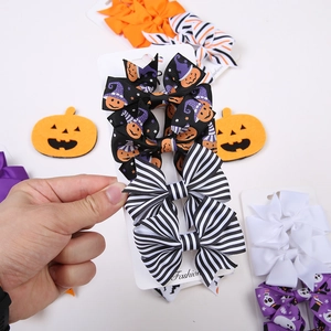 Dettaglio di fiocchi per capelli Halloween con stampe di zucca e fantasma su carta