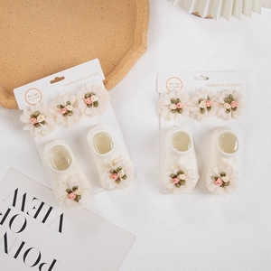 Detalle de set de diadema y calcetines para bebé con flores de gasa 3D y rosas