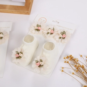 Detalle de conjunto de diadema y calcetines para bebé con flores de satén hechas a mano