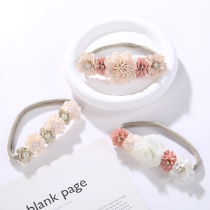 Detailed view of three handmade flower headbands for babies with pearls and rhinestones