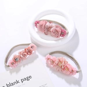 Detailed close-up of a three-piece baby headband set with soft fabric floral decorations