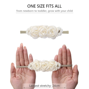 Detail showing the elastic stretch of the cream floral baby headband up to 24cm length